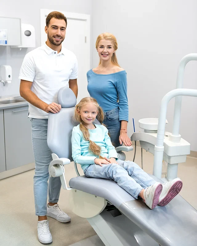 A family of three sitting together in a dental chair at a Family Dentistry clinic