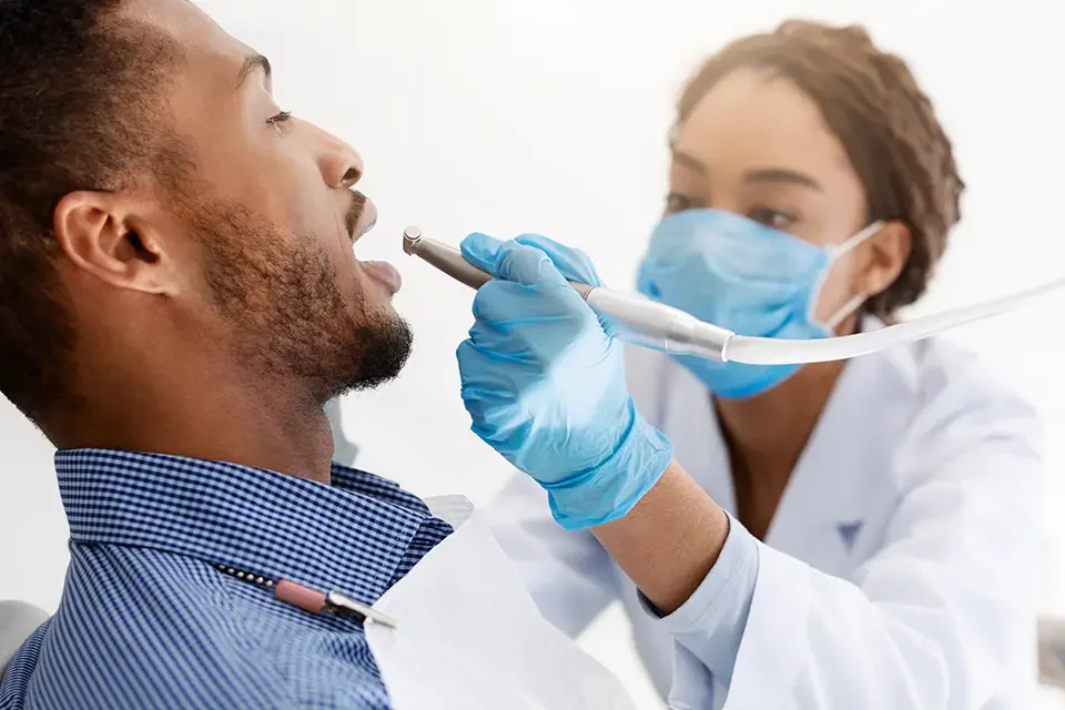 african-woman-dentist-drilling-patient-teeth-close Common Oral Health Problems and Their Cosmetic Solutions