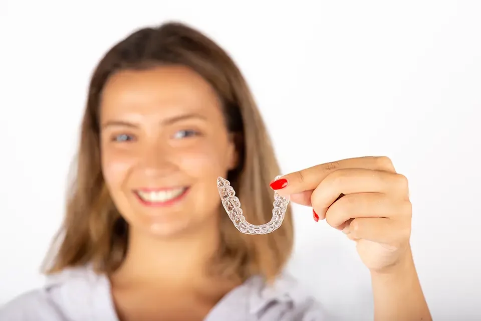 beautiful-smiling-young-woman-with-aligner Daily Habits That Reduce the Need to Ask "Why Does My Invisalign Hurt??"