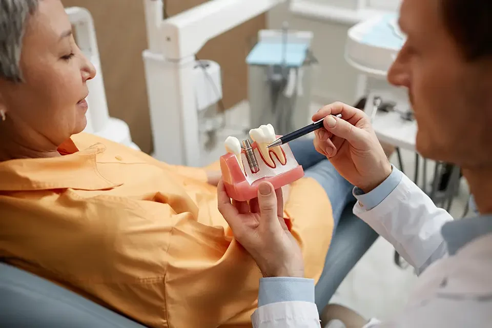 closeup-of-male-dentist-explaining-dental-implant Do Dental Implants Hurt? The Weeks After