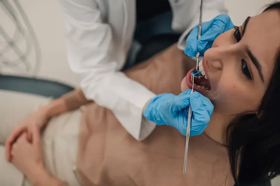 dentist-examining-patient-s-teeth-with-dental-tool Causes Leading to a Dental Necrosis Diagnosis