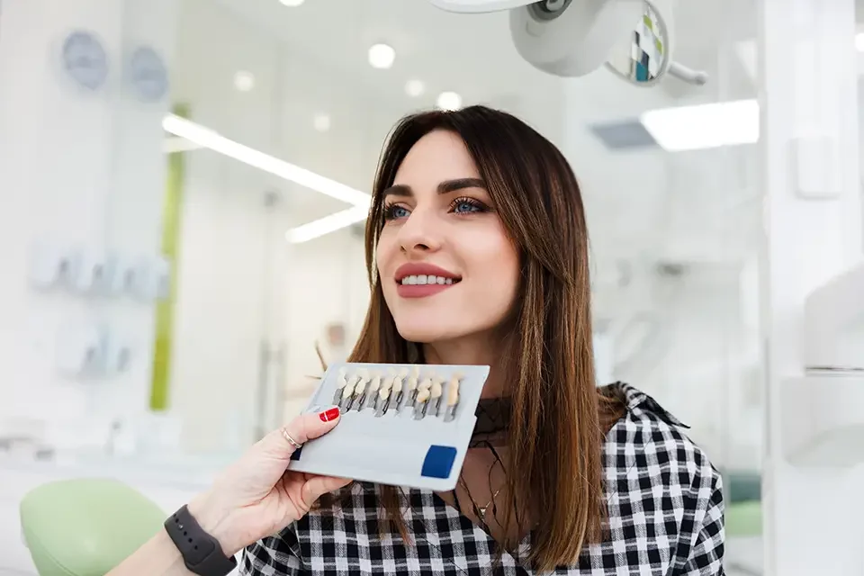 dentist-selects-a-shade-of-teeth-for-the-patient Factors Affecting Whitening Cost