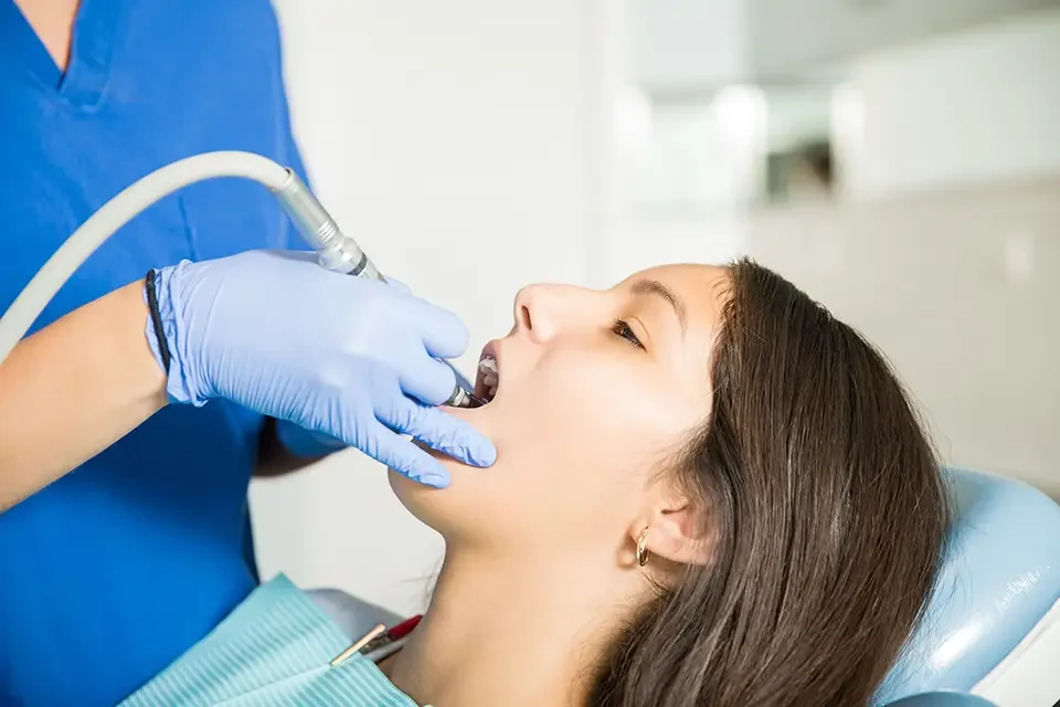 girl-receiving-treatment-with-tool-from-dentist What Causes Dental Fillings to Fail: The Real Reasons