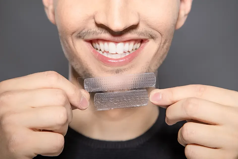 man-with-whitening-stripes-in-front-of-his-smiling How to Use Whitening Strips Safely