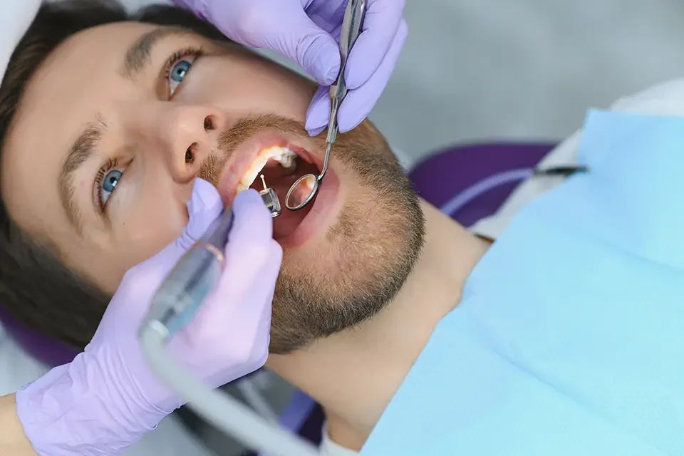 young-man-at-the-dentist-dental-care-taking-care Prevention Plan: What Causes Dental Fillings to Fail